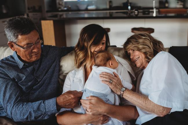 Newborn-Lifestyle-Photographer-Perth-24-of-50 Mother and grandparents on couch with newborn baby during Perth lifestyle newborn photography session