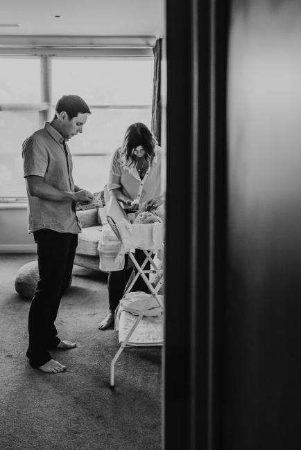 Newborn-Lifestyle-Photographer-Perth-32-of-50 black and white image of parents changing newborn baby during Perth lifestyle newborn photography session