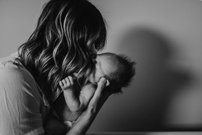 Newborn-Lifestyle-Photographer-Perth-33-of-50 black and white image of mother kissing newborn baby during Perth lifestyle newborn photography session