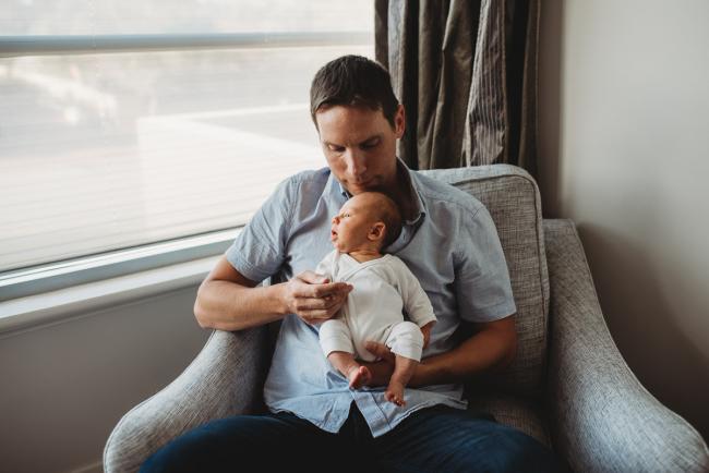 Newborn-Lifestyle-Photographer-Perth-40-of-50 Father holding newborn baby on chair during Perth lifestyle newborn photography session
