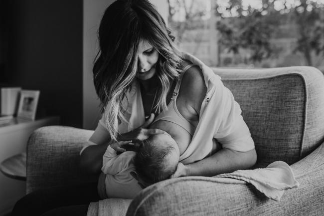 Newborn-Lifestyle-Photographer-Perth-5-of-50 black and white image of mother breastfeeding newborn baby on chair during Perth lifestyle newborn photography session