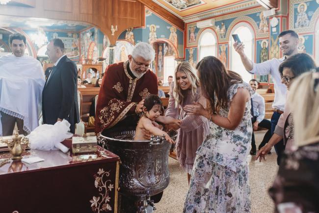 Perth-Events-Photographer-Christening-10-of-25 People watching little girl being baptised in water at baptism at Macedonian Orthodox Church with Perth events photographer