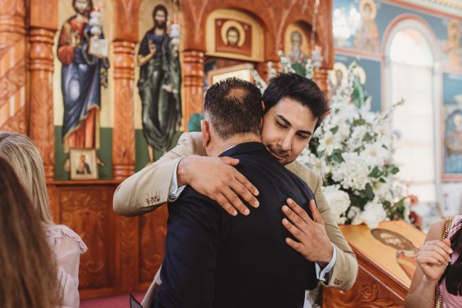 Perth-Events-Photographer-Christening-21-of-25 Father and son hugging at baptism at Macedonian Orthodox Church with Perth events photographer