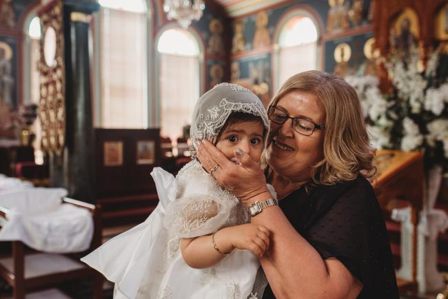 Perth-Events-Photographer-Christening-23-of-25 Woman kissing little girl at baptism at Macedonian Orthodox Church with Perth events photographer