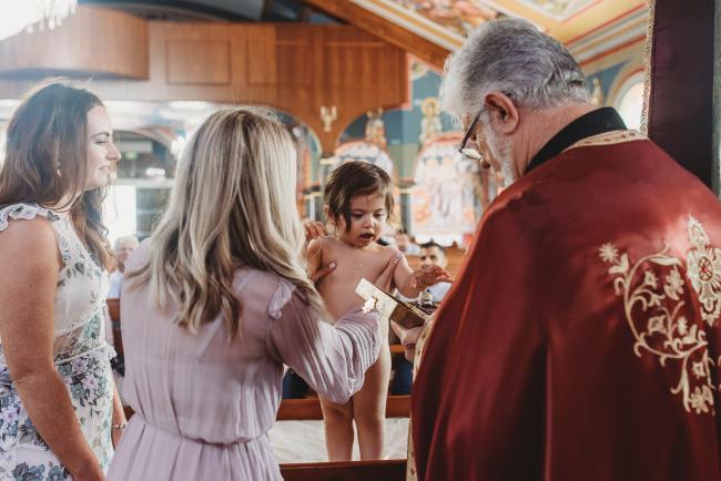 Perth-Events-Photographer-Christening-7-of-25 Little girl getting changed at baptism at Macedonian Orthodox Church with Perth events photographer