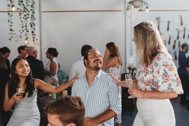Women touching mans shoulders during a party at Cleaver St Event Space with Perth events photographer