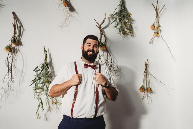 Man holding his braces during a party at Cleaver St Event Space with Perth events photographer