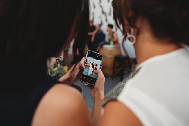 Women looking at photo on a phone during a party at Cleaver St Event Space with Perth events photographer