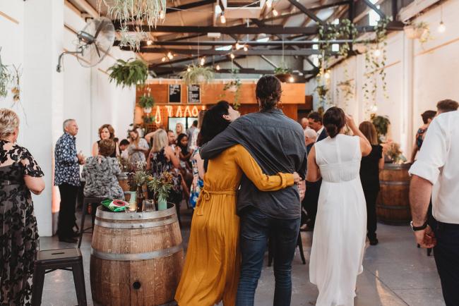 Couple arm in arm walking away during a party at Cleaver St Event Space with Perth events photographer