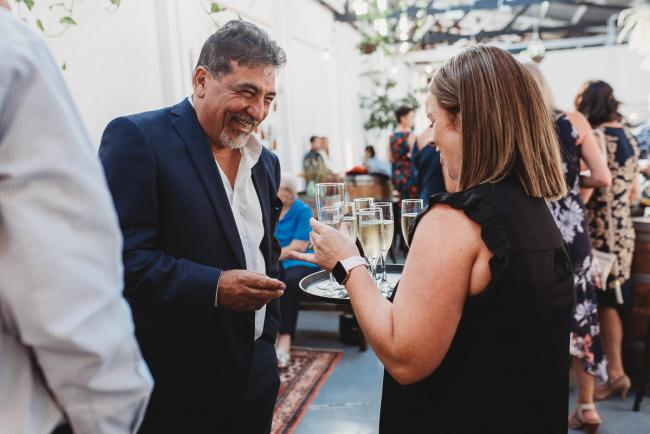 Man taking glass of champaigne from waittress during a party at Cleaver St Event Space with Perth events photographer