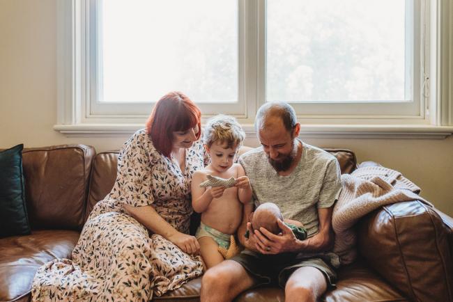 Family of four on couch during in-home Perth newborn lifestyle photography session
