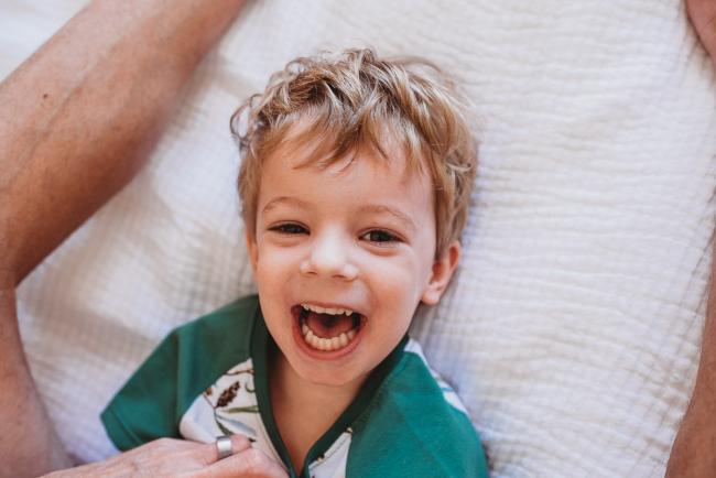 Little boy laughing during in-home Perth newborn lifestyle photography session