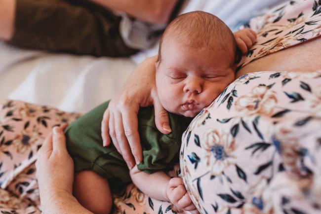 Newborn baby sleeping on mother's chest with Perth newborn lifestyle photographer