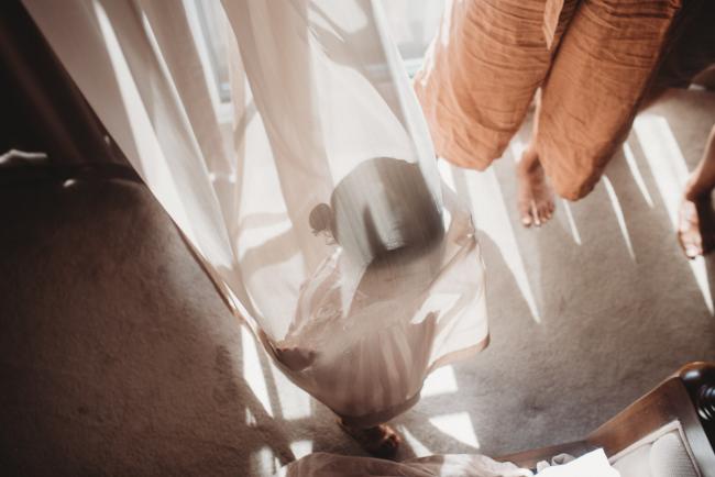 Little girl playing in curtains with in-home Perth lifestyle newborn photographer