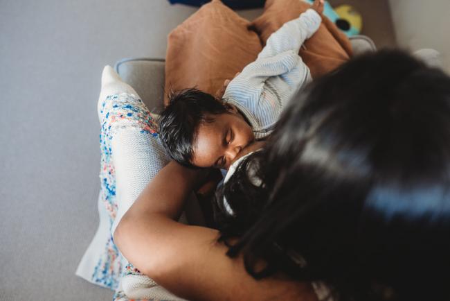 Top down image of newborn baby breastfeeding with in-home Perth lifestyle newborn photographer
