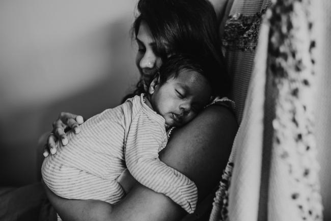 black and white image of newborn baby sleeping on mother's shoulder with Perth newborn photographer