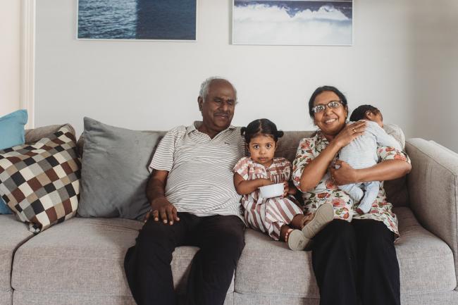 Grandparents on the couch with granddaughter and newborn baby with in-home Perth lifestyle newborn photographer