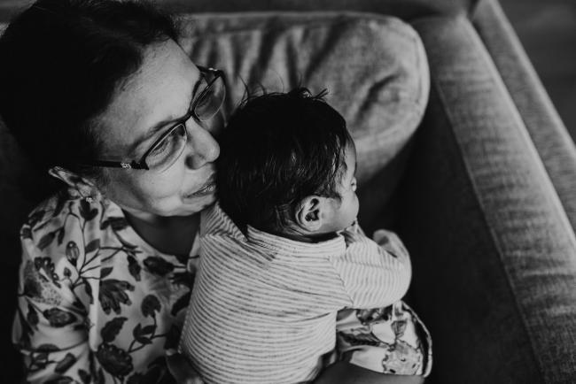 Black and white image of grandmother holding newborn baby with in-home Perth lifestyle newborn photographer