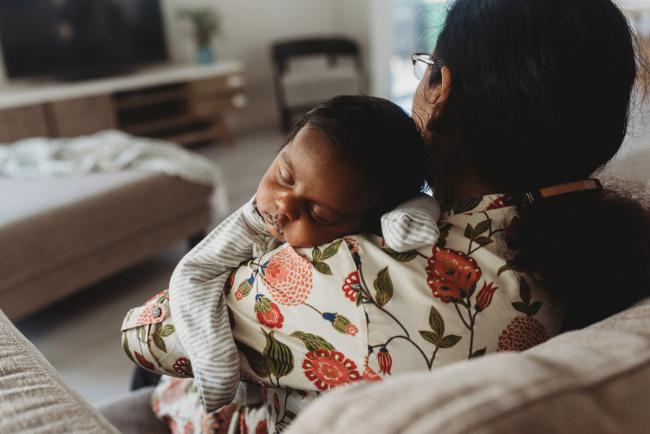 Newborn baby sleeping on grandmother's shoulder with in-home Perth lifestyle newborn photographer