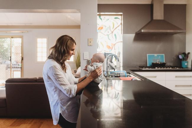 Mother holding baby on kitchen bench with Perth Newborn photographer Alana Prosper Photography