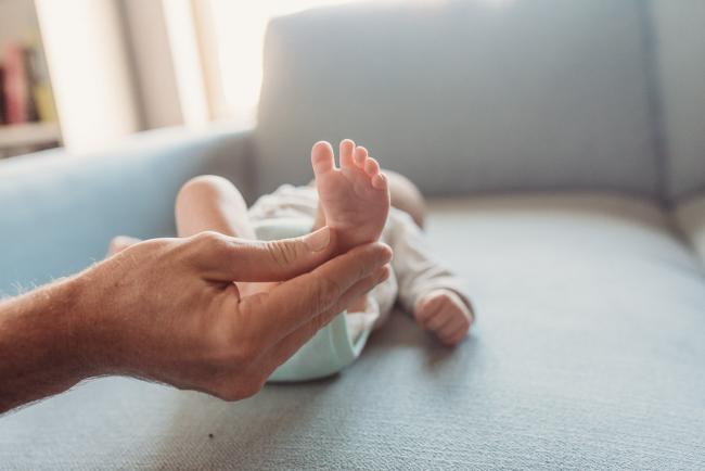 Father holding baby's foot with Perth Newborn photographer Alana Prosper Photography