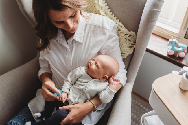 Mother holding baby who is looking up at her with Perth Newborn photographer Alana Prosper Photography