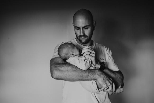 black and white image of father holding baby with Perth Newborn photographer Alana Prosper Photography
