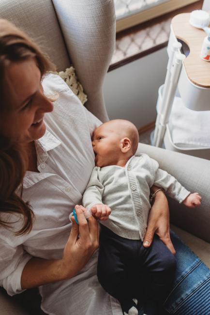 Baby trying to breastfeed through mother's top with Perth Newborn photographer Alana Prosper Photography