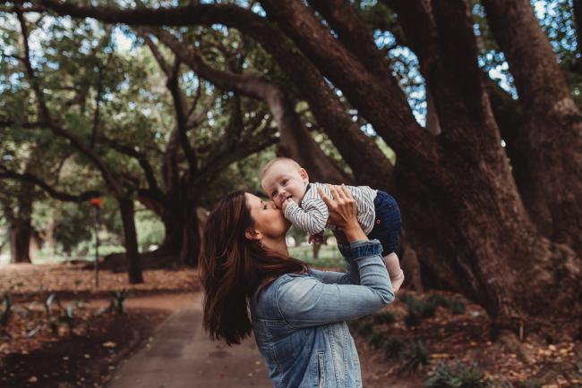 Mother lifting baby in the air during extended family session at Hyde Park with Perth family photographer Alana Prosper Photography