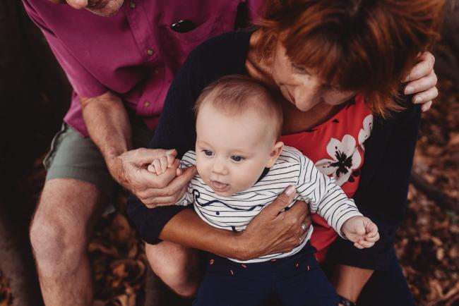 Baby on lap of grandparents during extended family session at Hyde Park with Perth family photographer Alana Prosper Photography