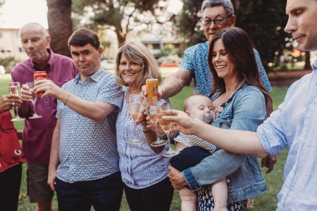 Family doing cheers with wine glasses during extended family session at Hyde Park with Perth family photographer Alana Prosper Photography