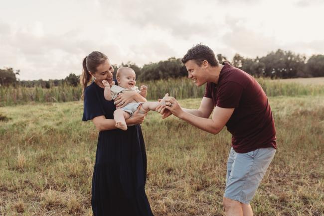 Mother holding baby as father tickles his toes with Perth Family Photographer Alana Prosper Photography at Perry's Paddock