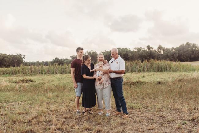Baby being held by parents and grandparents with Perth Family Photographer Alana Prosper Photography at Perry's Paddock