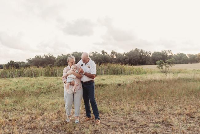 Baby being held by grandparents with Perth Family Photographer Alana Prosper Photography at Perry's Paddock