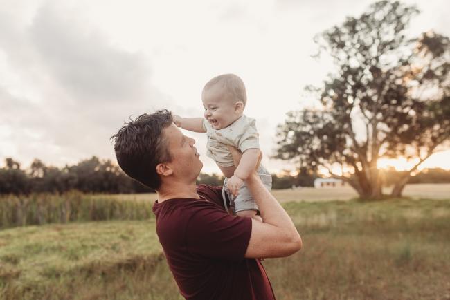 Father lifting baby with Perth Family Photographer Alana Prosper Photography at Perry's Paddock