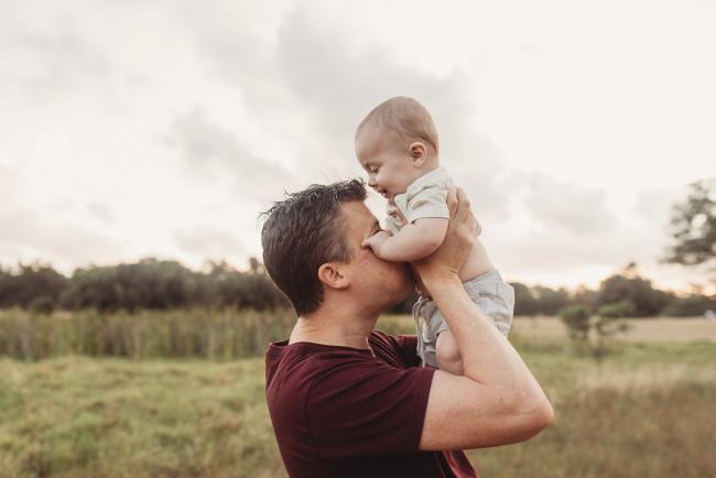Father blowing raspberries on baby tummy with Perth Family Photographer Alana Prosper Photography at Perry's Paddock