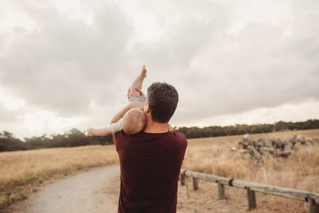 Father lifting baby upside down over his shoulder with Perth Family Photographer Alana Prosper Photography at Perry's Paddock