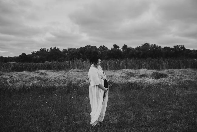 Black and white image of pregnant woman in field with Perth maternity photographer at Perry's Paddock