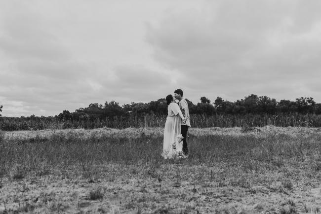 Black and white image of pregnant couple kissing with Perth maternity photographer at Perry's Paddock
