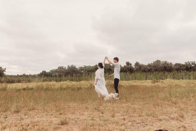 Pregnant couple dancing with Perth maternity photographer at Perry's Paddock