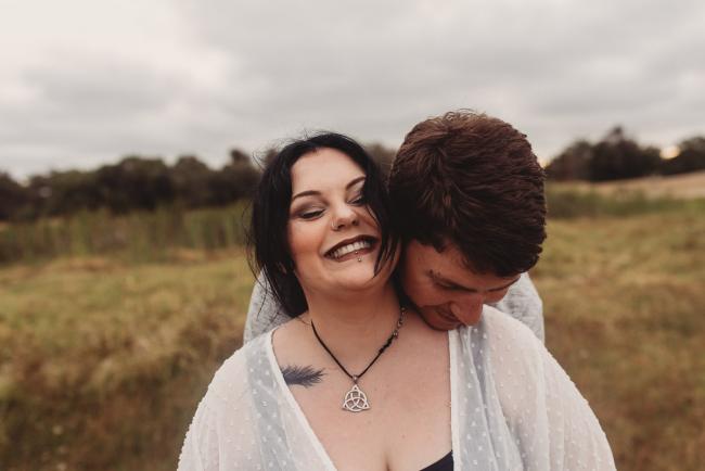 Woman laughing as partner leans head on her shoulder with Perth maternity photographer at Perry's Paddock