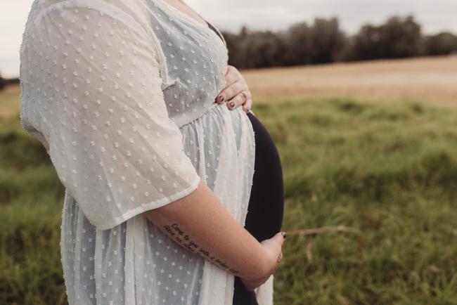 Close up of pregnant tummy during Perth maternity photography session during golden hour at Perry's Paddock
