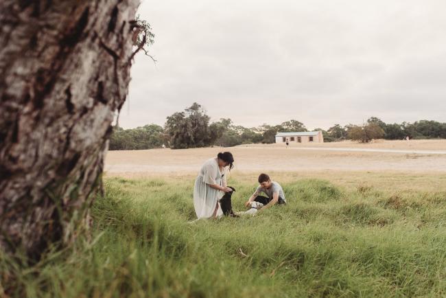Pregnant couple playing with dogs with Perth maternity photographer at Perry's Paddock