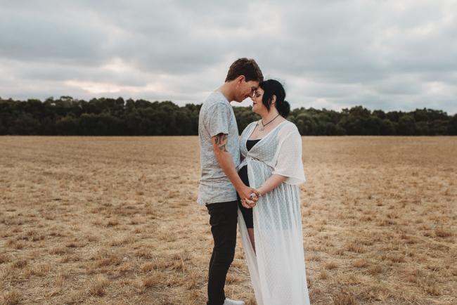 Pregnant couple holding hands with Perth maternity photographer at Perry's Paddock