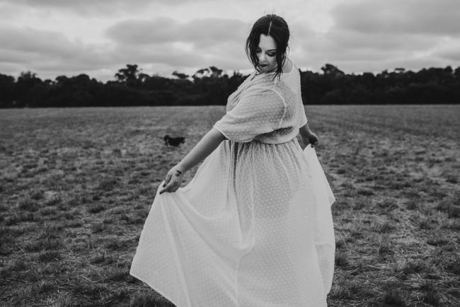 black and white image of pregnant woman spinning with Perth maternity photographer at Perry's Paddock
