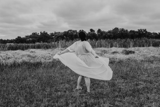 Black and white image of pregnant woman spinning around with Perth maternity photographer at Perry's Paddock