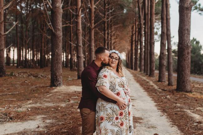 Man kissing woman at The Pines with Perth maternity photographer Alana Prosper Photography