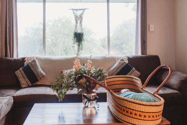 baby in bassinet on coffee table in lounge room with Perth newborn lifestyle photographer Alana Prosper Photography