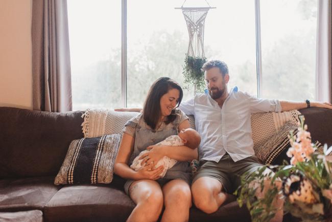 Parents on couch with newborn baby with Perth newborn lifestyle photographer Alana Prosper Photography