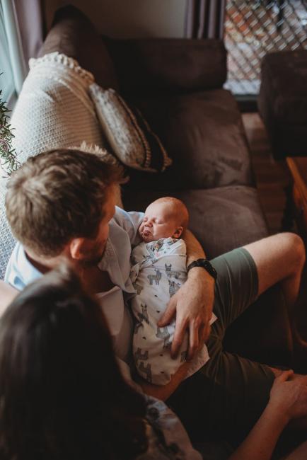 baby making a face in father's arms with Perth newborn photographer Alana Prosper Photography